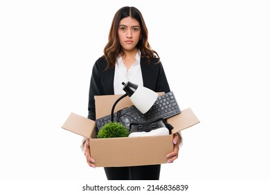 Portrait Of A Sad Latin Woman Getting Fired From Work And Carrying Her Office Supplies On A Box