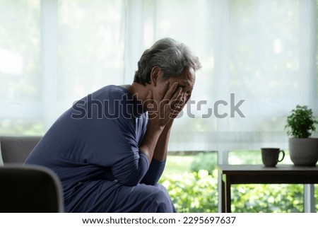 Portrait of sad and lonely Asian senior woman in living room