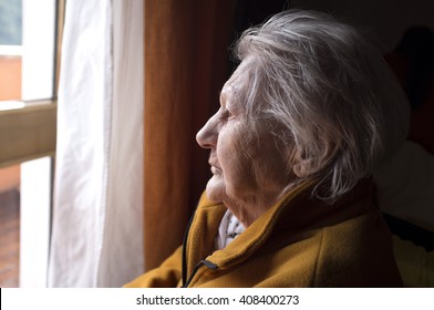 Portrait Of Sad Lonely Pensive Old Senior Woman Looking In A Window