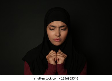 Portrait Of Sad Muslim Woman In Hijab  Praying On Dark Background