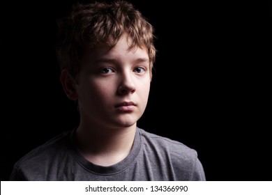 Portrait Sad Teenage Boy On A Black Background