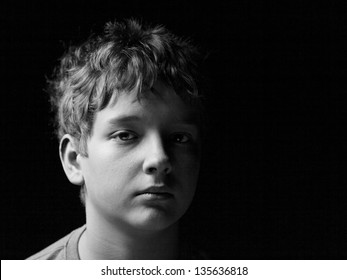 Portrait Sad Teenage Boy On A Black Background