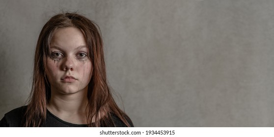 Portrait Of A Sad Teenager On Gray Background. Empty Space For Text