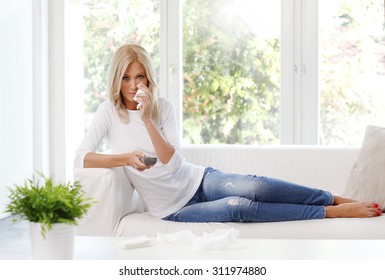 Portrait Of Sad Woman With Handkerchief Sitting At Sofa And Holding Hand Remote Control While Watching Bad Movie. 