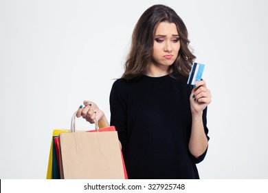 Portrait Of A Sad Woman Holding Shopping Bags And Bank Card Isolated On A White Background