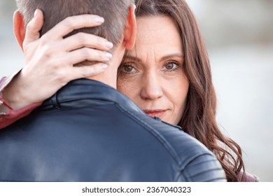 Portrait of a sad woman hugging her boyfriend from behind in the street - Shutterstock ID 2367040323