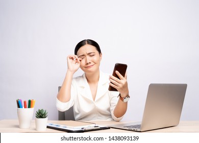 Portrait of sad woman used smartphone at office isolated over background