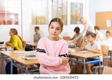 Portrait of sad young girl standing in classroom during lesson in school.. - Shutterstock ID 2281039673