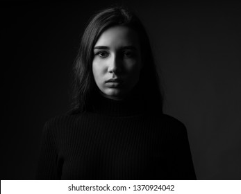 Portrait of a sad young woman. Black and white. Low key