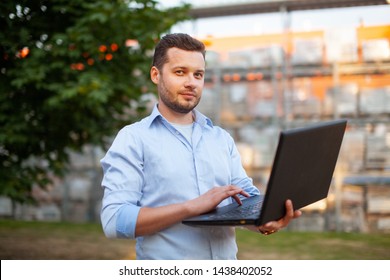 Portrait Of Sales Representative. Logistics Manager Typing On A Keyboard Of Laptop And Waiting His Business Partner To Have A Deal. Concept Of Warehouse Outdoor And Transportation Services. 
