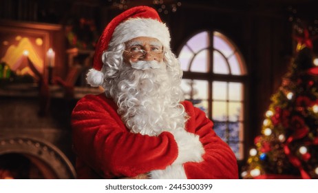 Portrait of Santa Claus Standing in a Festive Cozy Home with Fireplace, Decorations, Snow Falling Outside, Christmas Tree. Santa Looking at Camera, Smiling and Winking. Winter Holiday Celebrations - Powered by Shutterstock