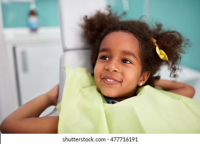 Portrait Of Satisfied Child In Dental Chair After Successful Dental Treatment