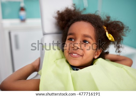 Portrait of satisfied child in dental chair after successful dental treatment