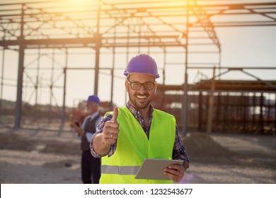 Portrait Of Satisfied Engineer Holding Tablet And Showing Thumb Up On Building Site