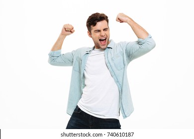 Portrait Of A Satisfied Young Man Celebrating Success Isolated Over White Background