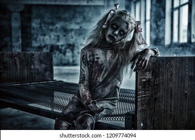 A portrait of a scary blonde zombie girl on a bed. Halloween. Horror film.