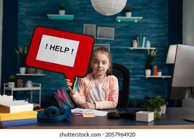 Portrait Of Schoolchild Struggling With Problem While Working At Mathematic Homework Holding Help Sign. Sad Little Kid Having Difficulties Studying For Online Academic Lesson During Home Schooling