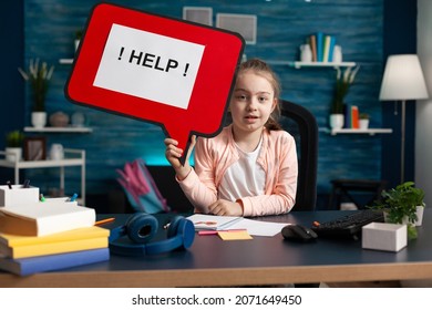 Portrait Of Schoolkid Struggling With School Problem While Working At Mathematic Homework Holding Help Sign. Little Kid Having Difficulties Studying For Online Academic Lesson During Home Schooling