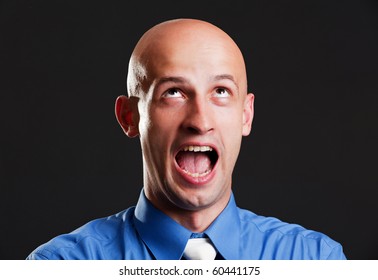 Portrait Of Screaming Bald Man Over Black Background