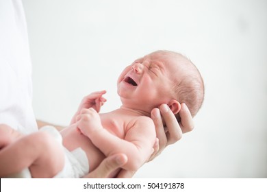 Portrait of a screaming newborn hold at hands, family, healthy birth concept photo, close up