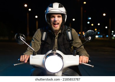 Portrait Of A Screaming Pizza Delivery Guy. A Man On A Scooter Delivers Products In The Evening In The City