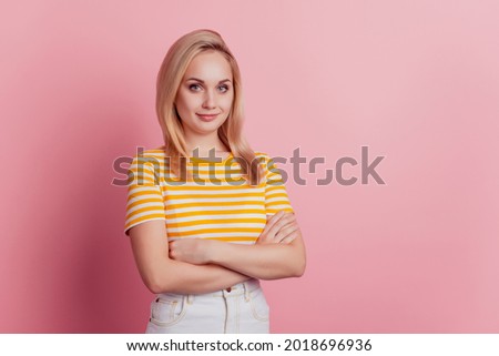 Portrait of self-assured business woman folded arms on pink background