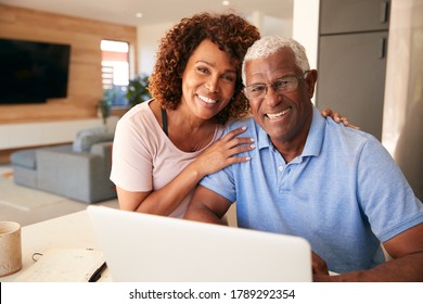 Portrait Of Senior African American Couple Using Laptop To Check Finances At Home