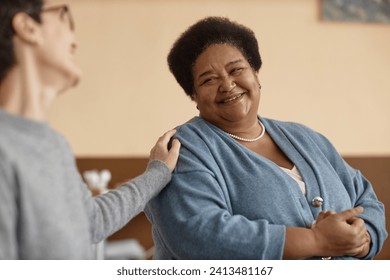 Portrait of senior African American woman smiling in group therapy session with people supporting her, copy space - Powered by Shutterstock