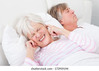 Portrait Of Senior Angry Woman Awaken By Her Husband Snoring - Powered by Shutterstock