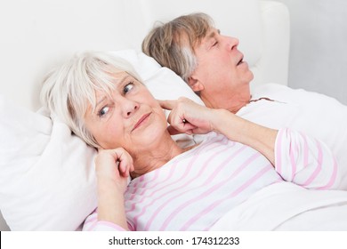 Portrait Of Senior Angry Woman Awaken By Her Husband Snoring - Powered by Shutterstock