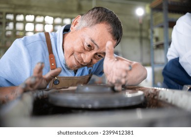 Portrait of a senior Asian couple doing activities together in the pottery workshop. - Powered by Shutterstock