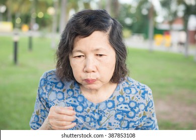 Portrait Of Senior Asian Woman Eating Dessert