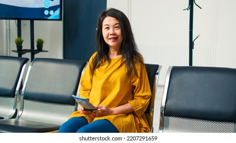 Portrait Of Senior Asian Woman In Hospital Waiting Room Having Checkup Appointment With Physician. Attending Medical Consultation With Specialist To Cure Disease And Get Treatment.