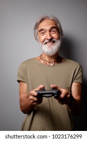 Portrait Of Senior Bearded Man Playing Video Games Using Playstation Controller.