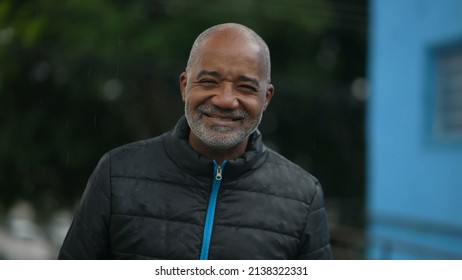 Portrait Of A Senior Black Man Standing Outside Smiling In The Drizzle Rain