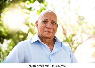 portrait of senior brazilian black man looking at camera in sunset and smiling. Horizontal shape, copy space