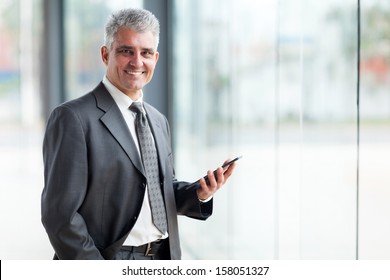 Portrait Of Senior Business Executive Using Tablet Pc