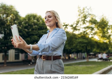 Portrait Of Senior Business Woman Using Smartphone In The City. Cheerful Mature Business Woman In Classic Wear