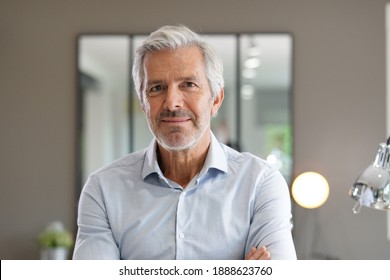 Portrait of senior businessman with arms crossed looking at camera - Shutterstock ID 1888623760