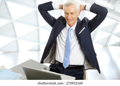 Portrait Of Senior Chief Financial Officer Sitting In Front Of Laptop At Desk While Sit Back And Relaxing At Office. 