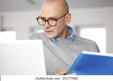 Portrait Of Senior Chief Financier Officer Sitting In Front Of Computer And Analyzing Data. Business People. 