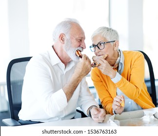 Portrait Of Senior Couple Eating Pizza