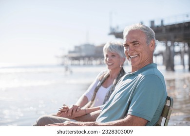 Portrait of senior couple relaxing on sunny beach - Powered by Shutterstock