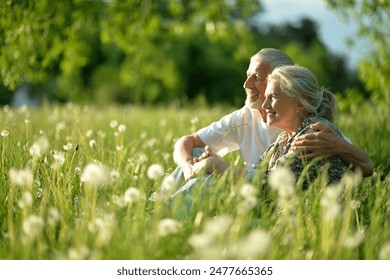 Portrait of senior couple sitting on the grass in the park. High quality photo - Powered by Shutterstock