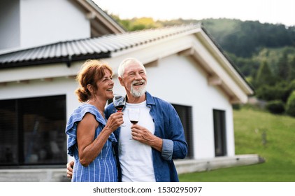 Portrait of senior couple with wine outdoors in backyard. - Powered by Shutterstock