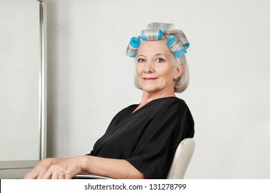 Portrait of senior female client with hair curlers at beauty salon - Powered by Shutterstock