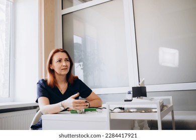 Portrait of senior female doctor on hospital corridor looking at camera smiling. - Shutterstock ID 2284417921