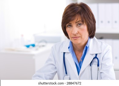 Portrait Of Senior Female Doctor Working At Office.