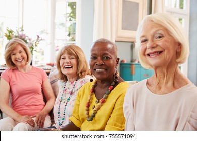 Portrait Of Senior Female Friends Relaxing On Sofa At Home