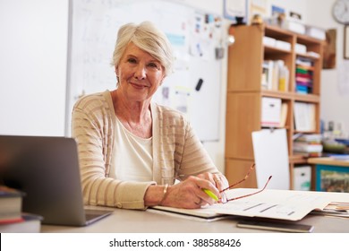 Portrait Of Senior Female Teacher Working At Her Desk